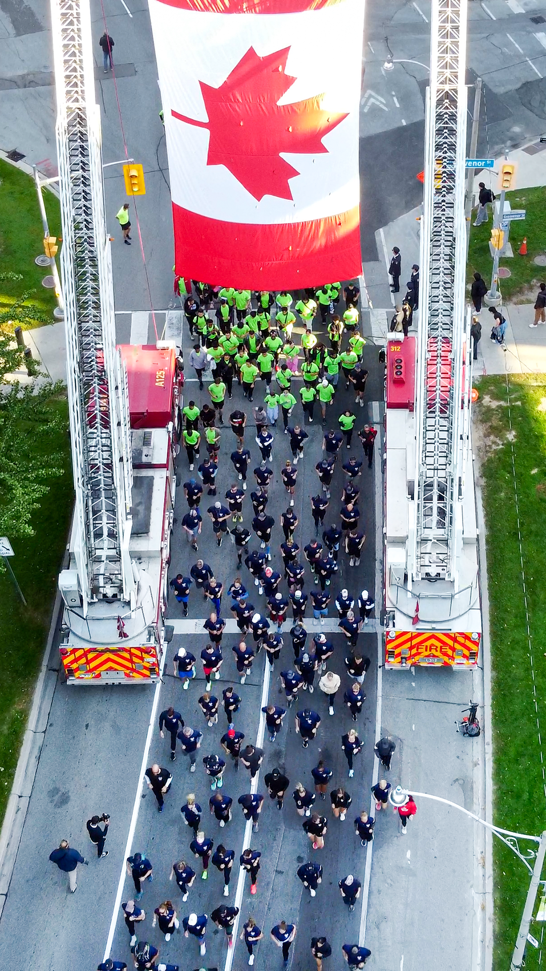 Group of people running under Canada flag
