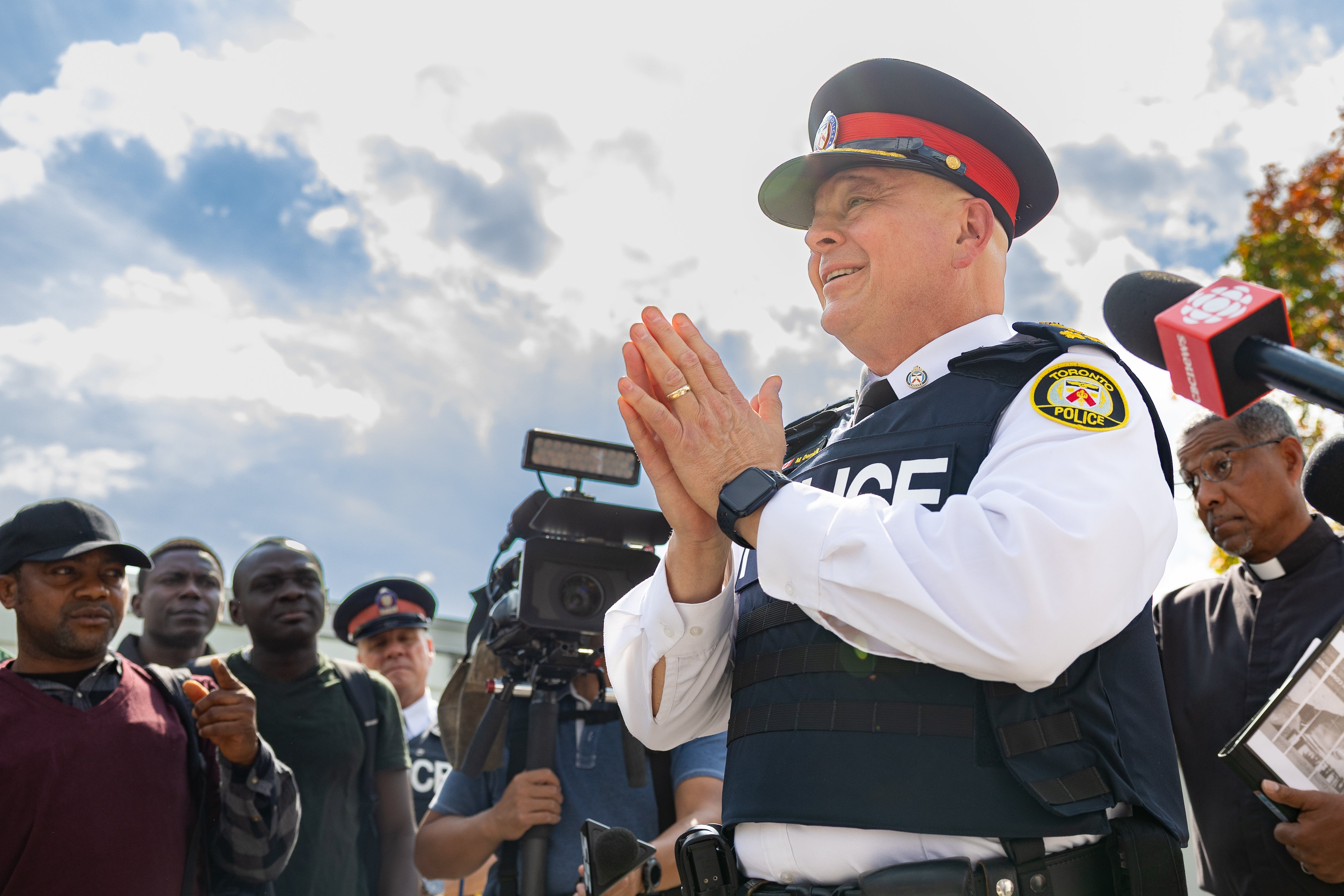 A police officer with his hands clasped in front of a crowd
