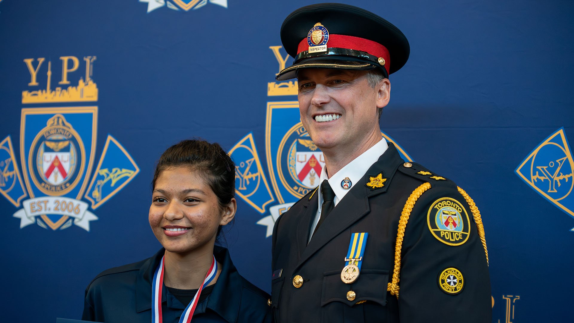 A person poses with a police officer