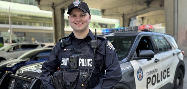 Police officer standing with police vehicle