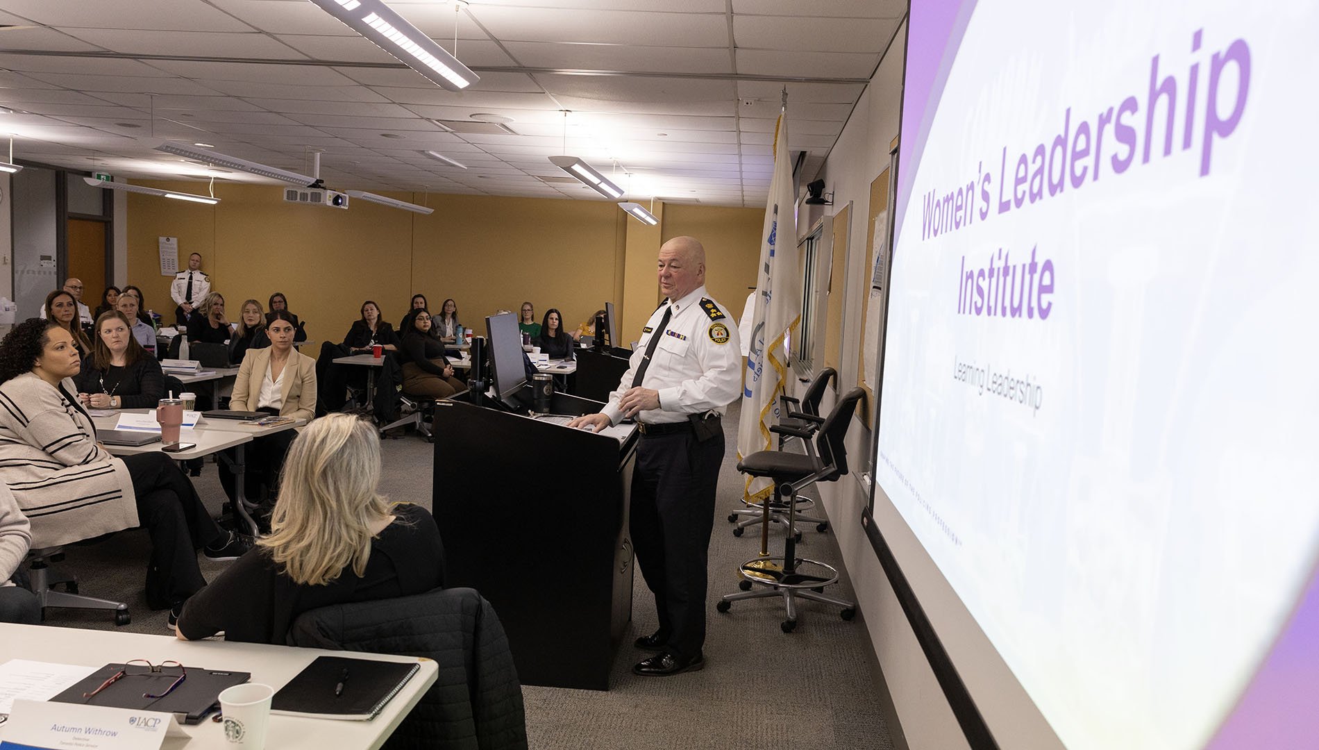 A police officer speaks to a classroom