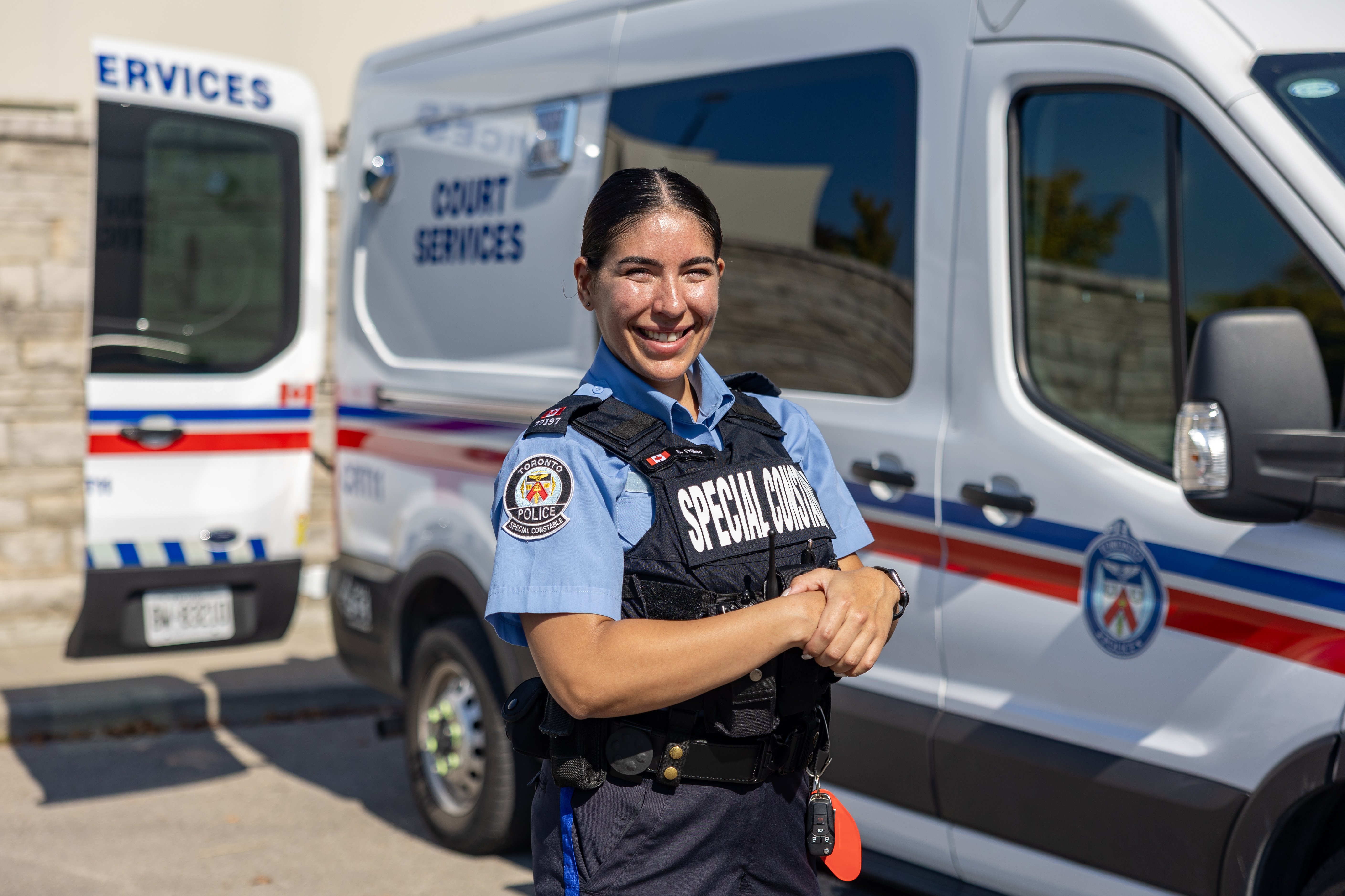 A female officer standing in front of a court services vehicle