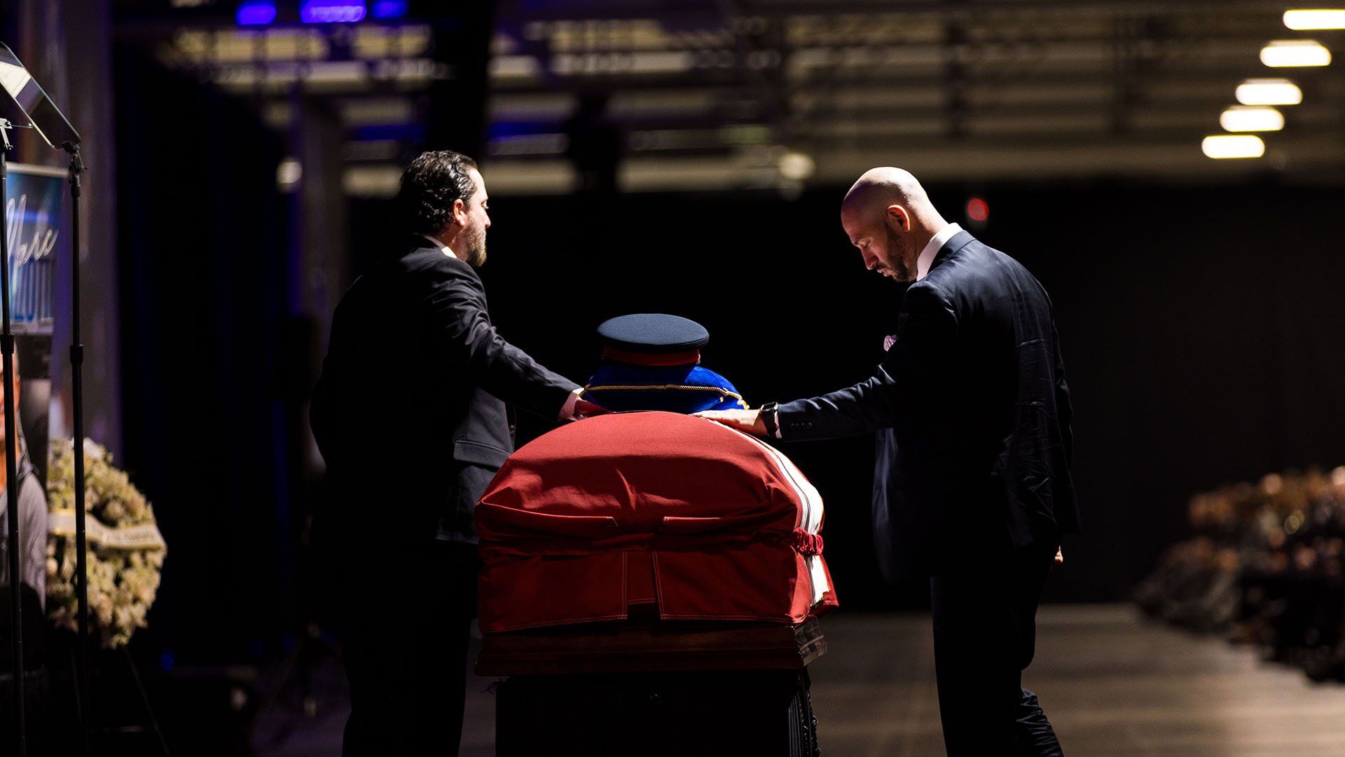 Two people touch a casket