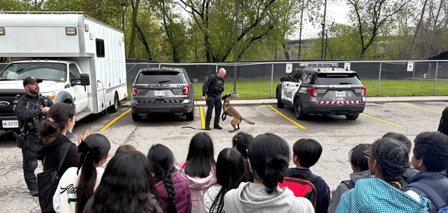 Students looking at a police officer and dog