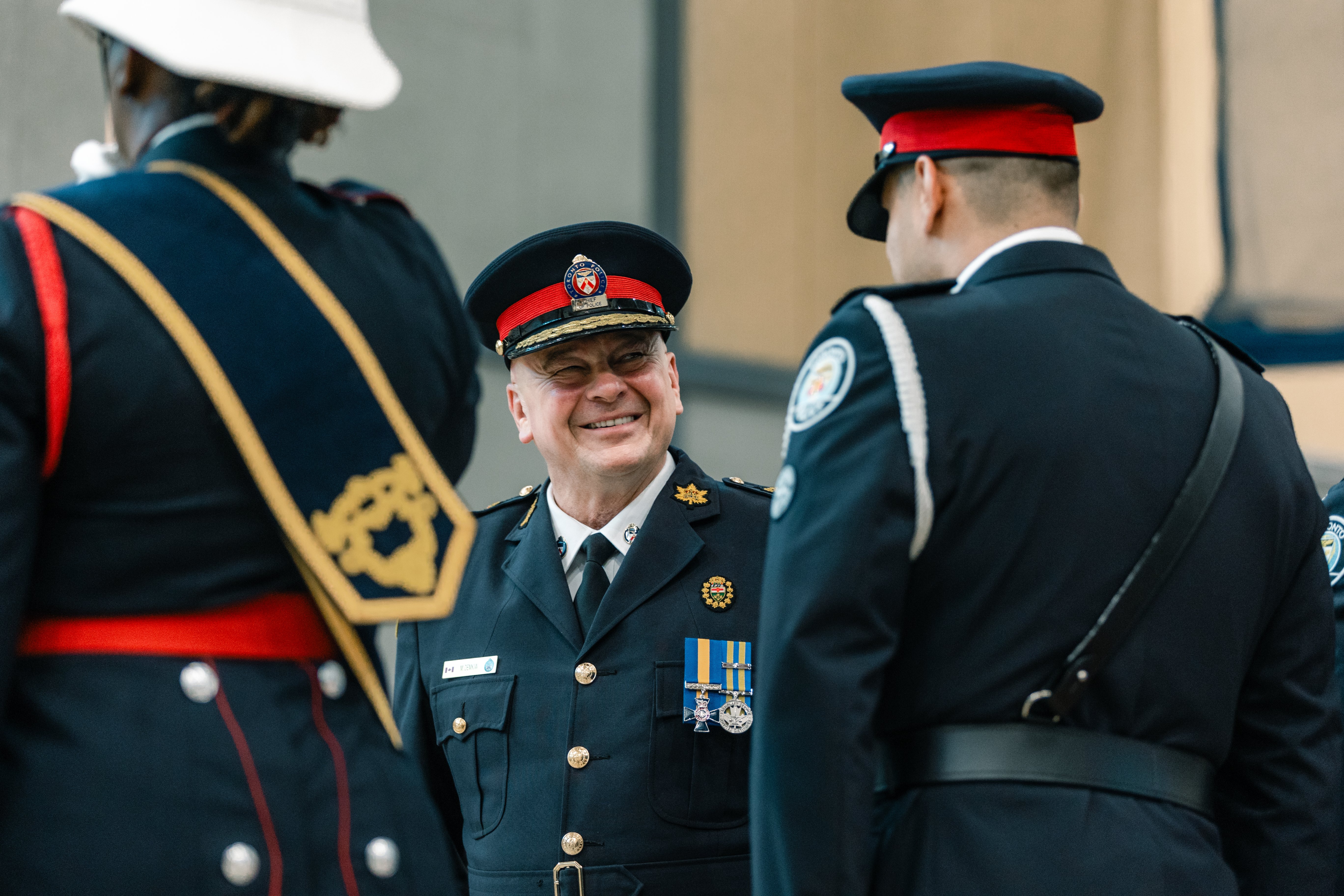 Chief of police walks by and smiles at a police officer