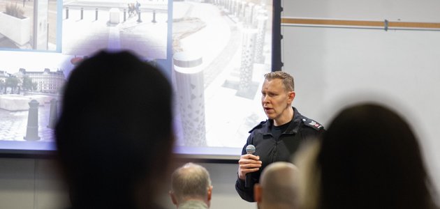 Police officer speaks to seated group