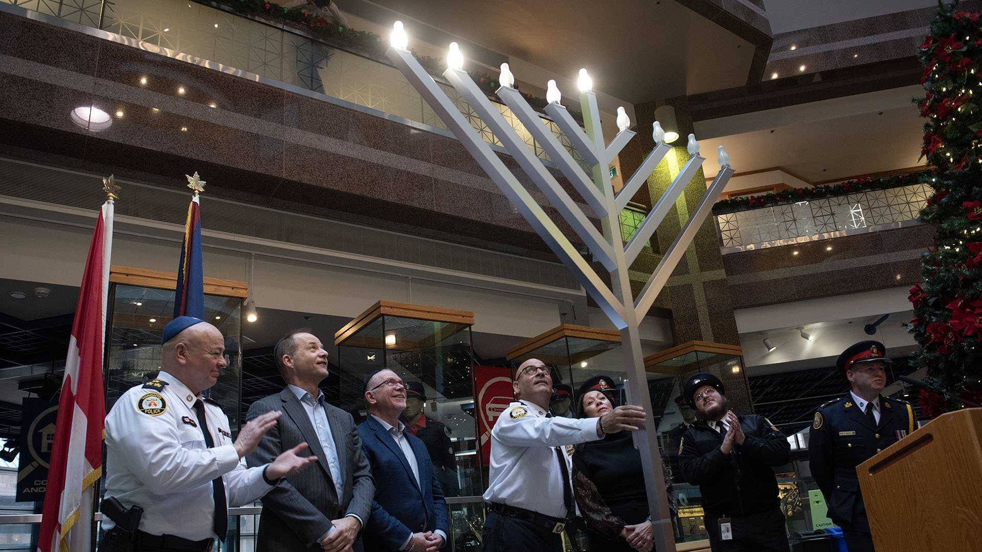People stand with large menorah