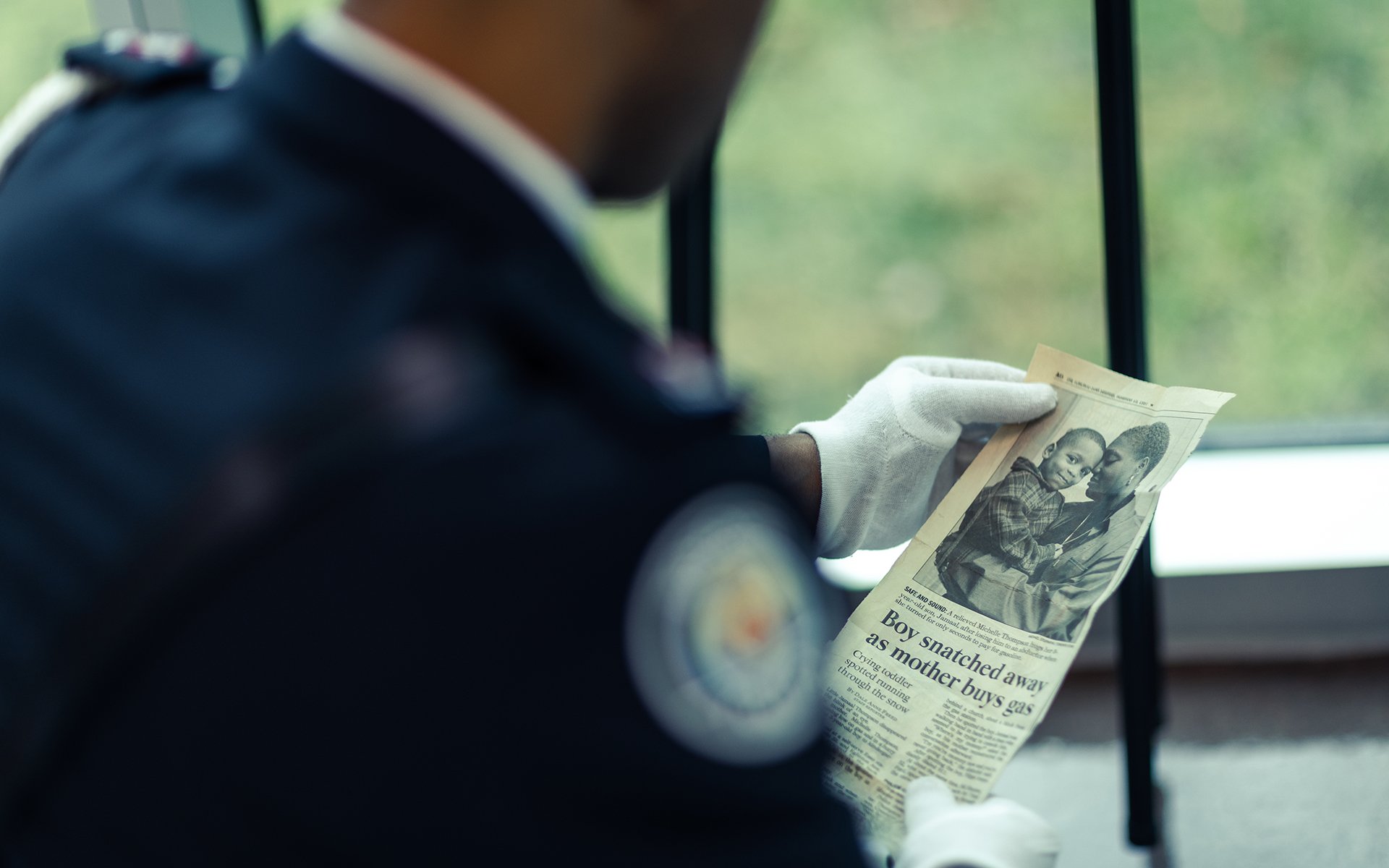 Police officer holding newspaper clipping