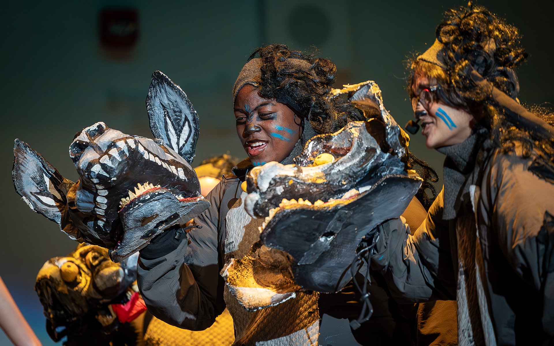 Young people on stage in hyena costumes