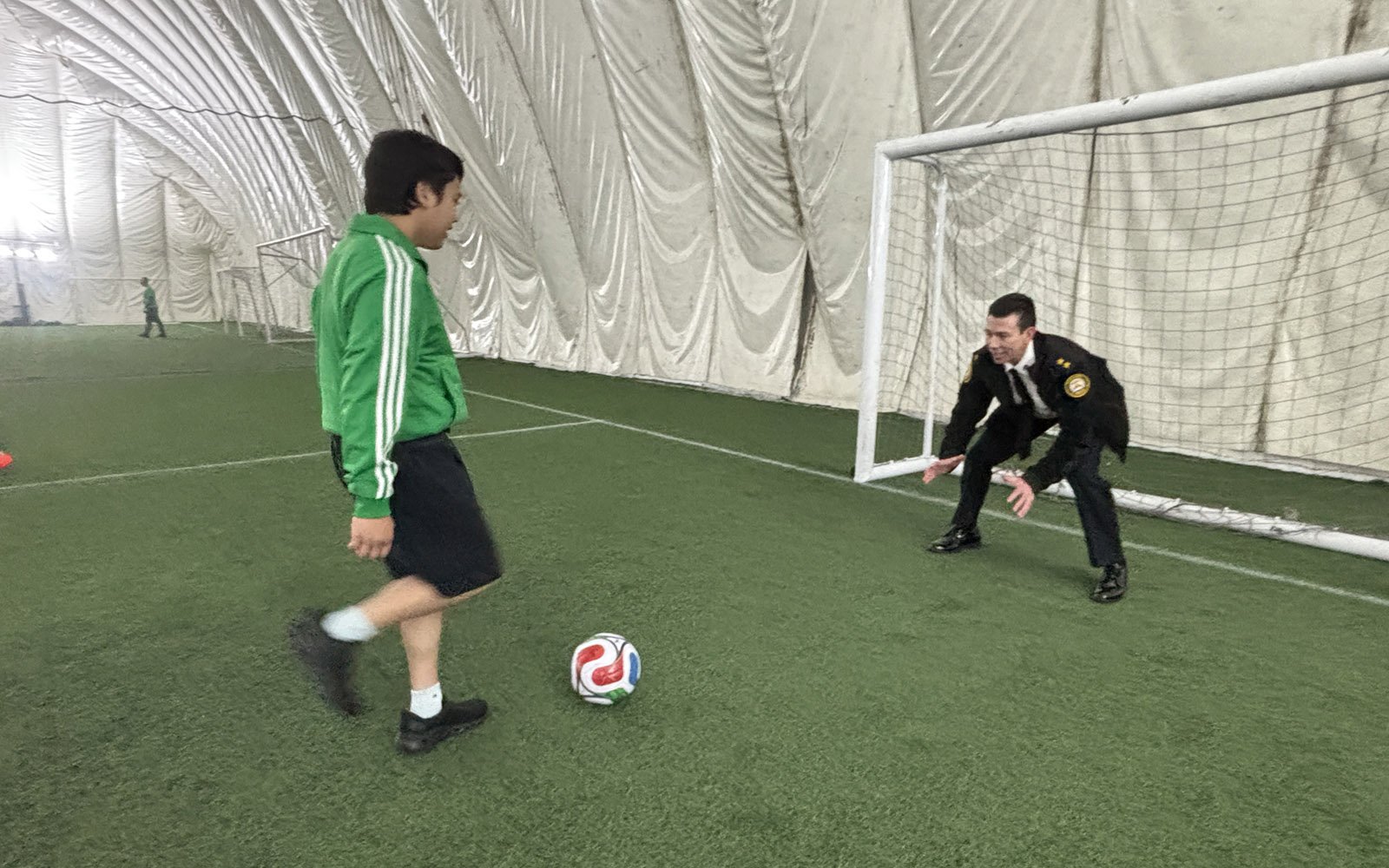 a boy is about to kick a ball at the goal