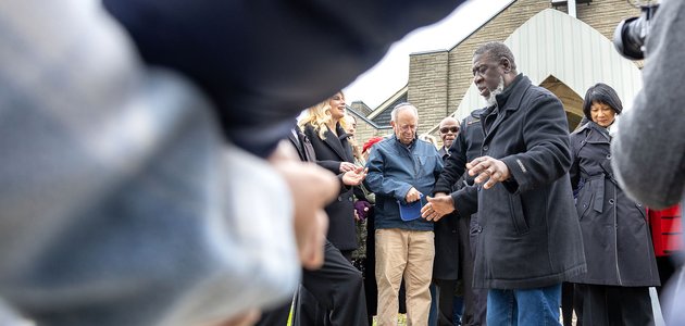 People holding hands in front of a church