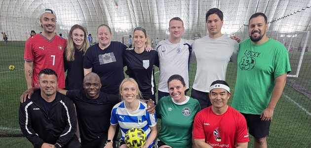 group of men and women in soccer outfits in an indoor field