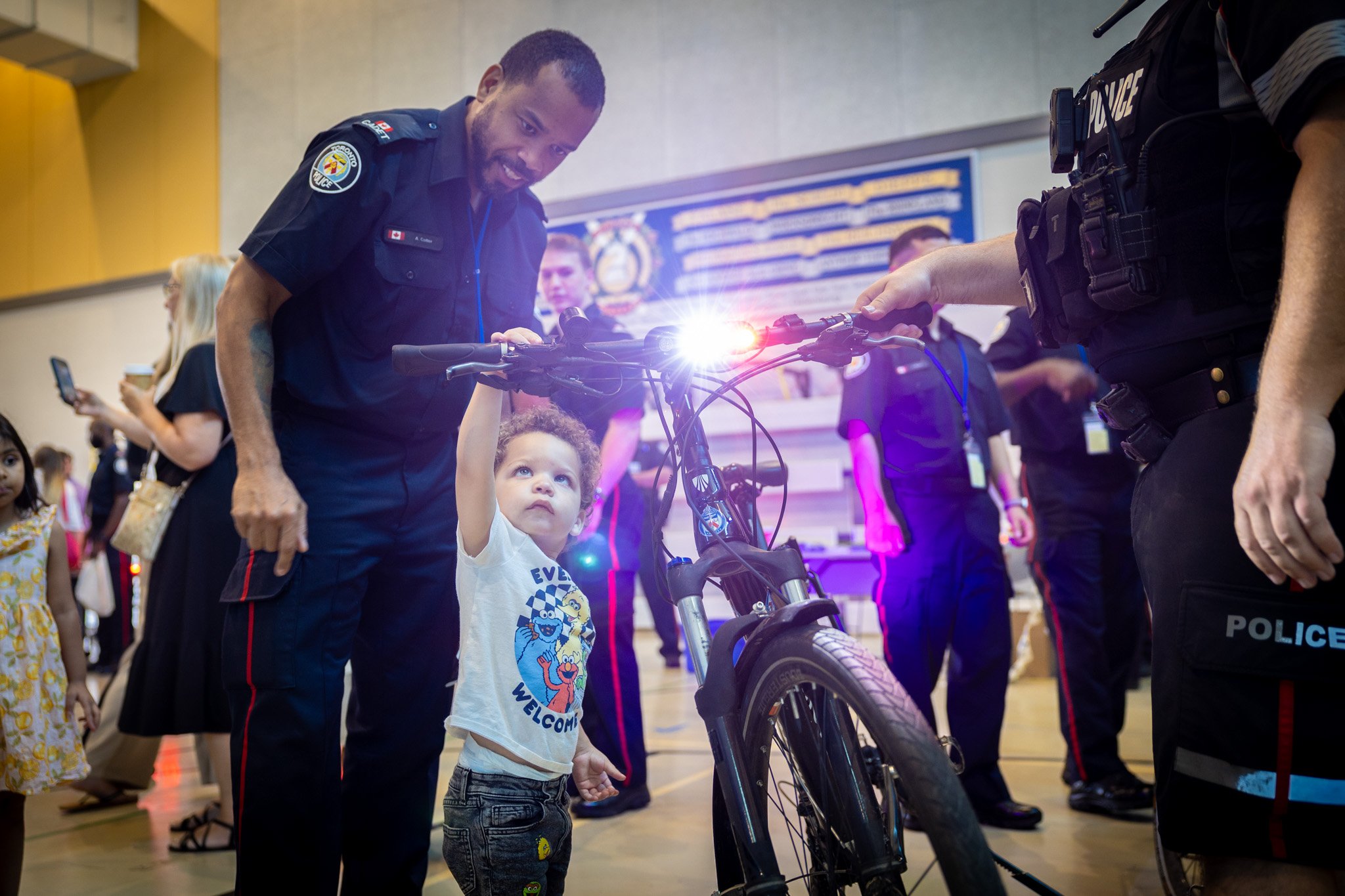 A child touching a bike with a man behind him