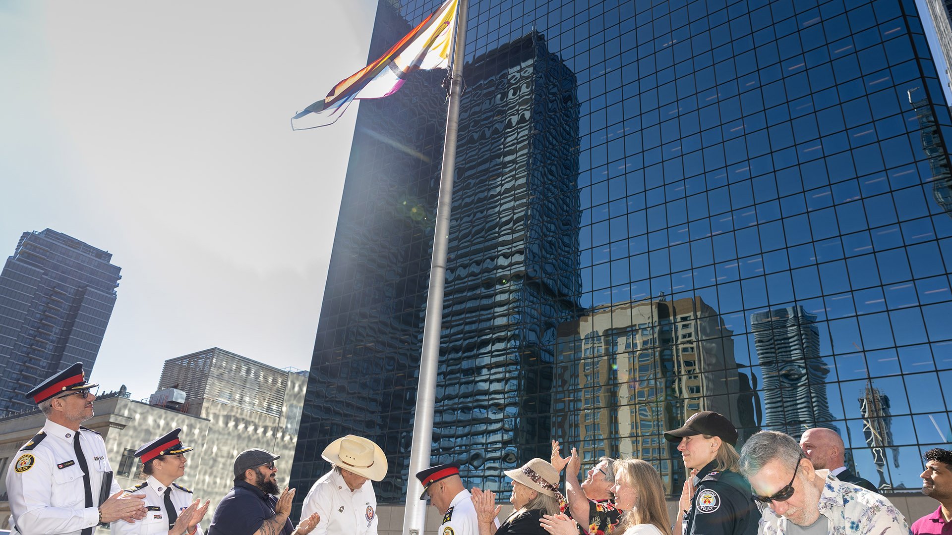 Group of people clapping as flag is raised