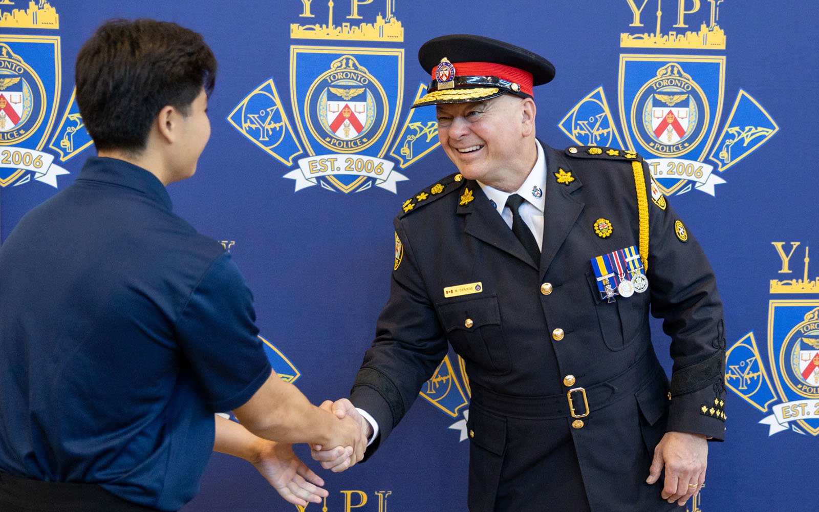 man in a uniform shaking hands with a student