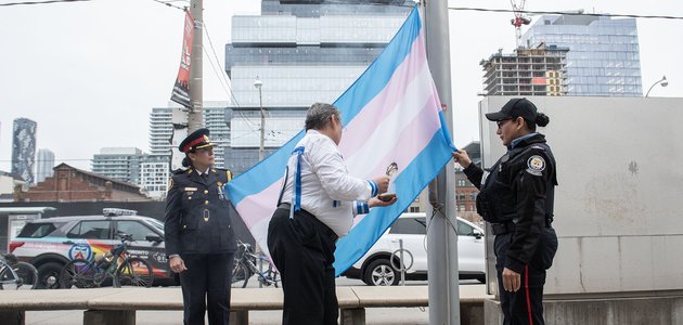 Three people stand with flag