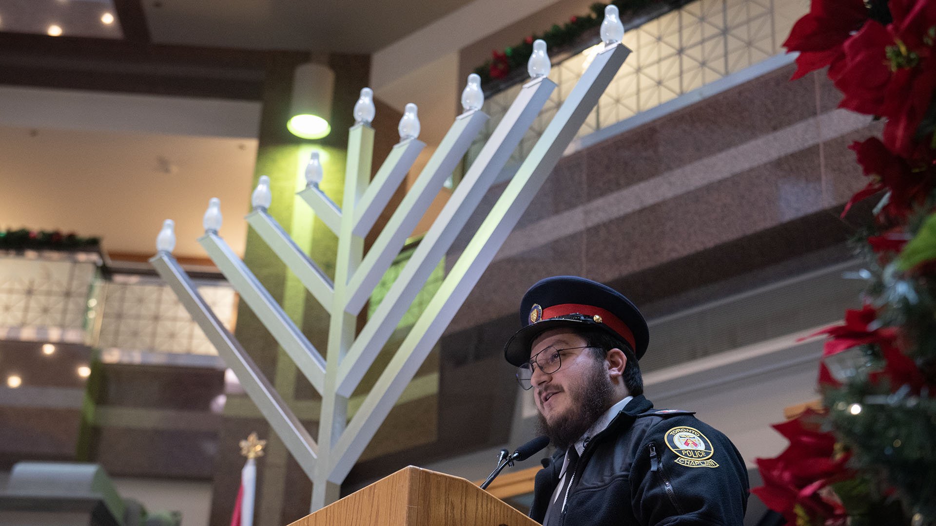 TPS chaplain beside a menorah.