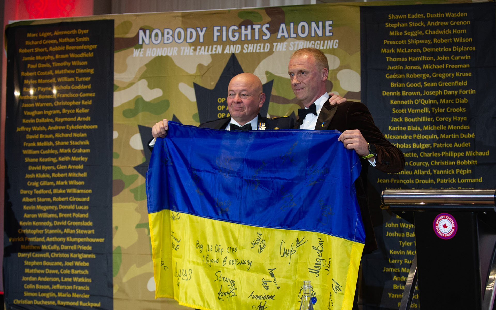 Two men hold flag