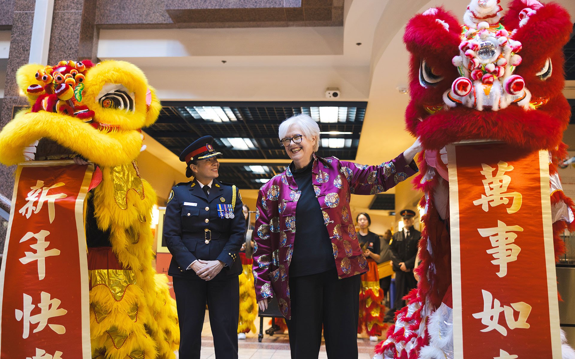 Two people standing with costume lions