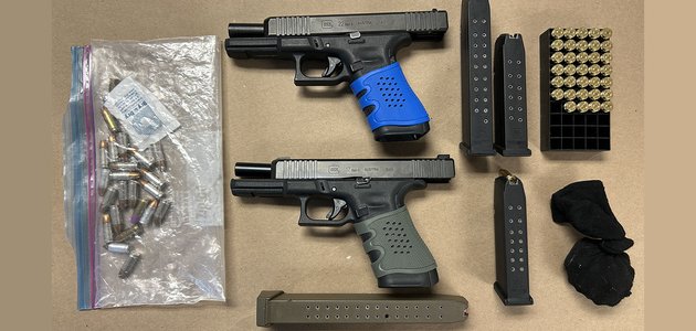 Two handguns and ammunition on a table