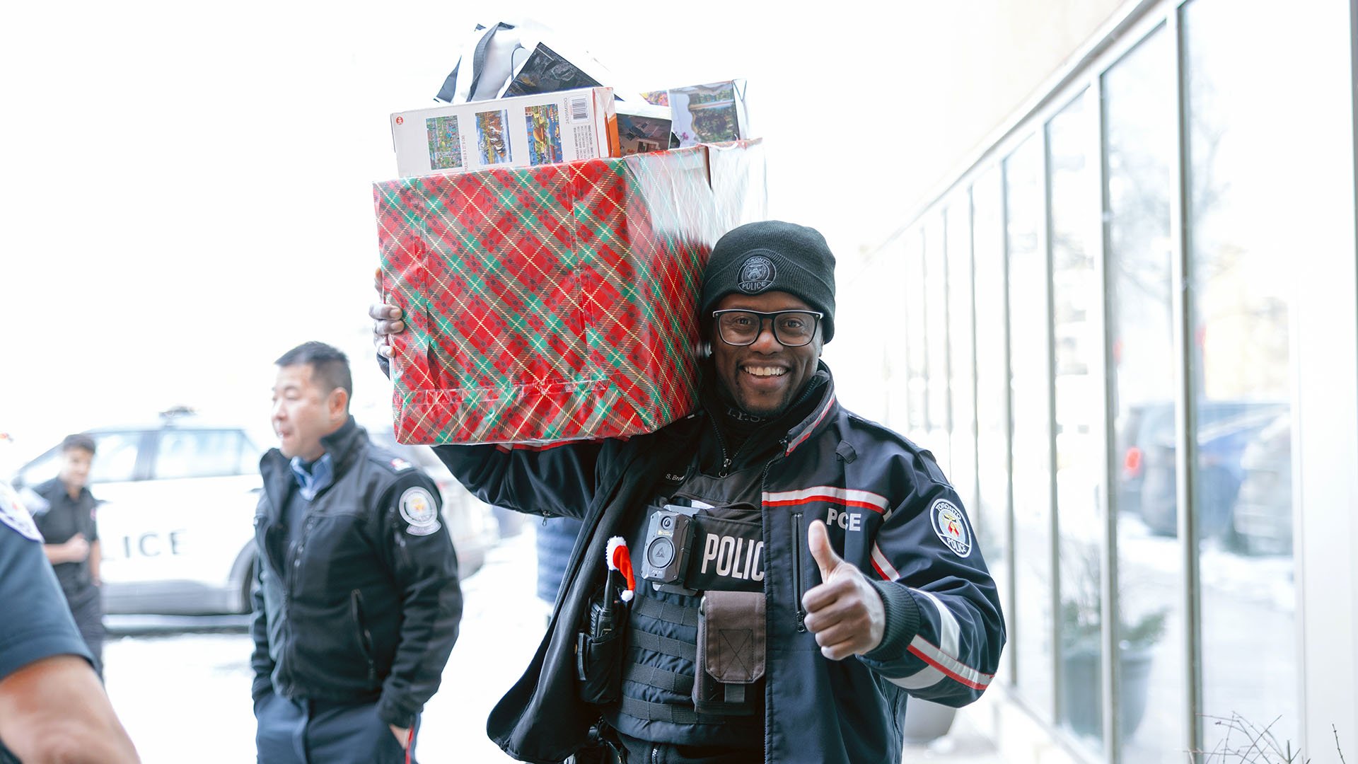 A police officer holding wrapped gifts.