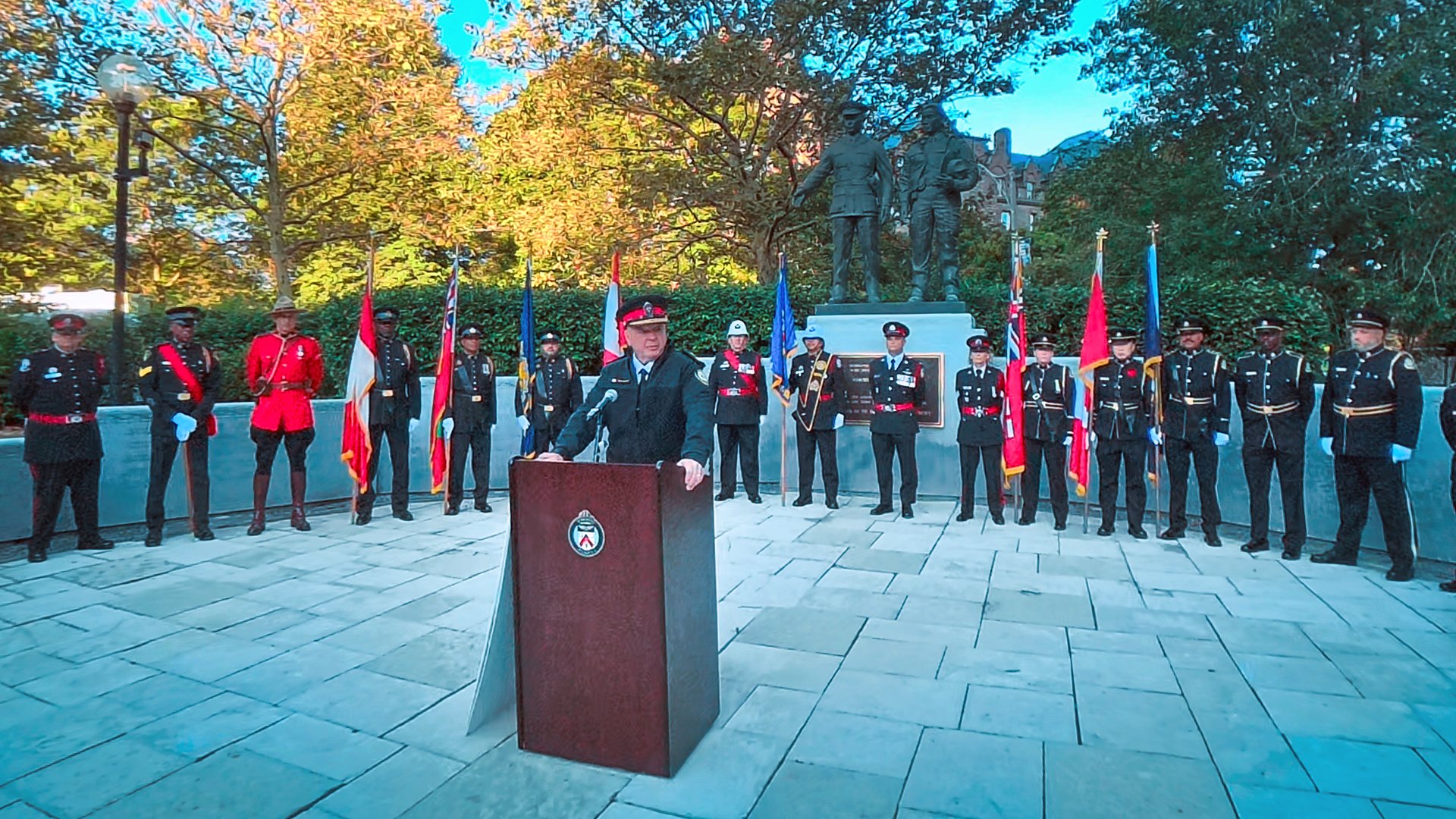 Police officer at a podium surrounded by uniform officers