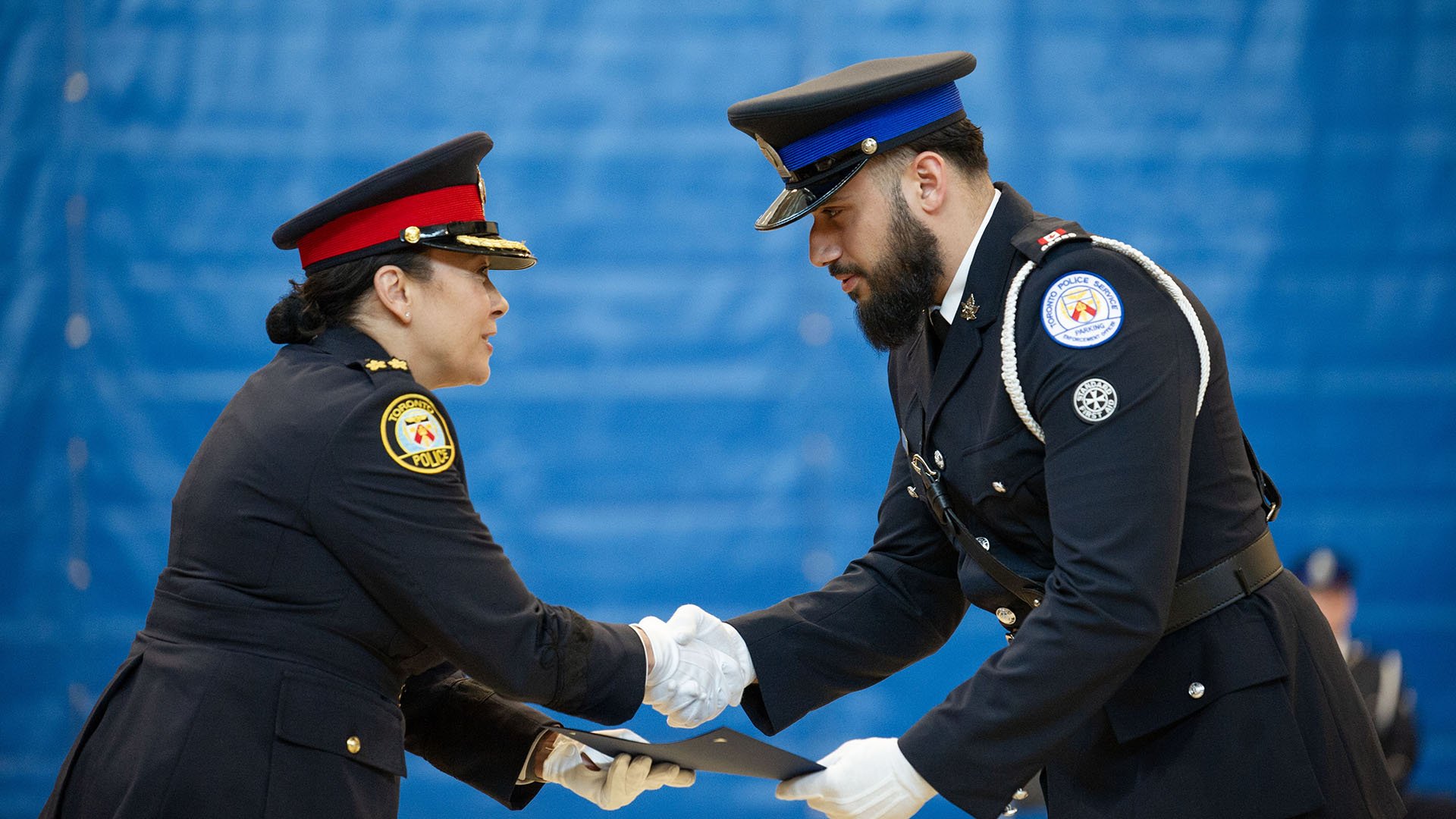 Two uniformed people shake hands