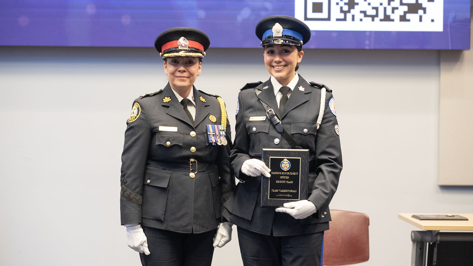 Two people stand with a plaque