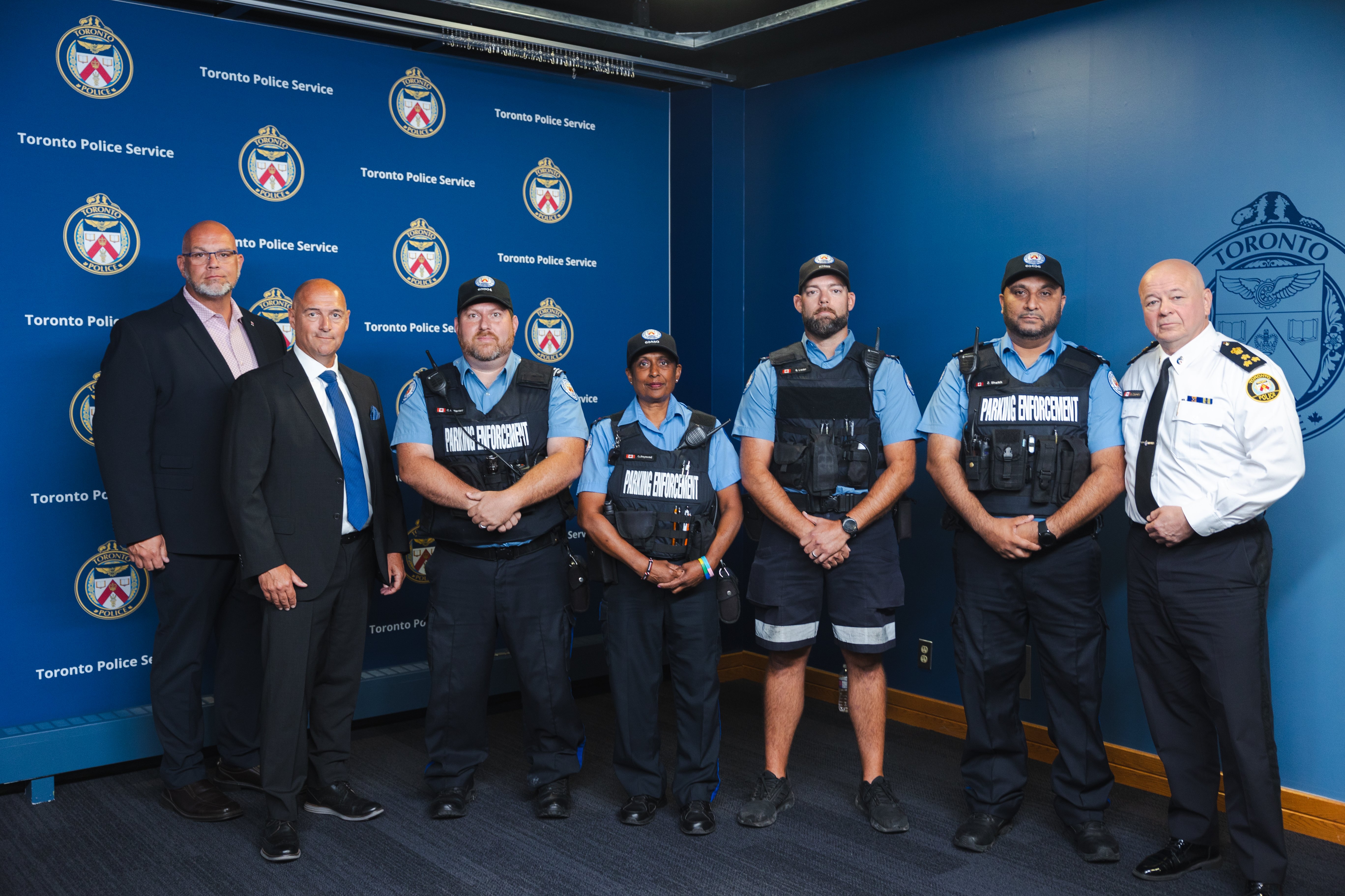 Members of Parking Enforcement stand with the Chief of Police and members of the TPA