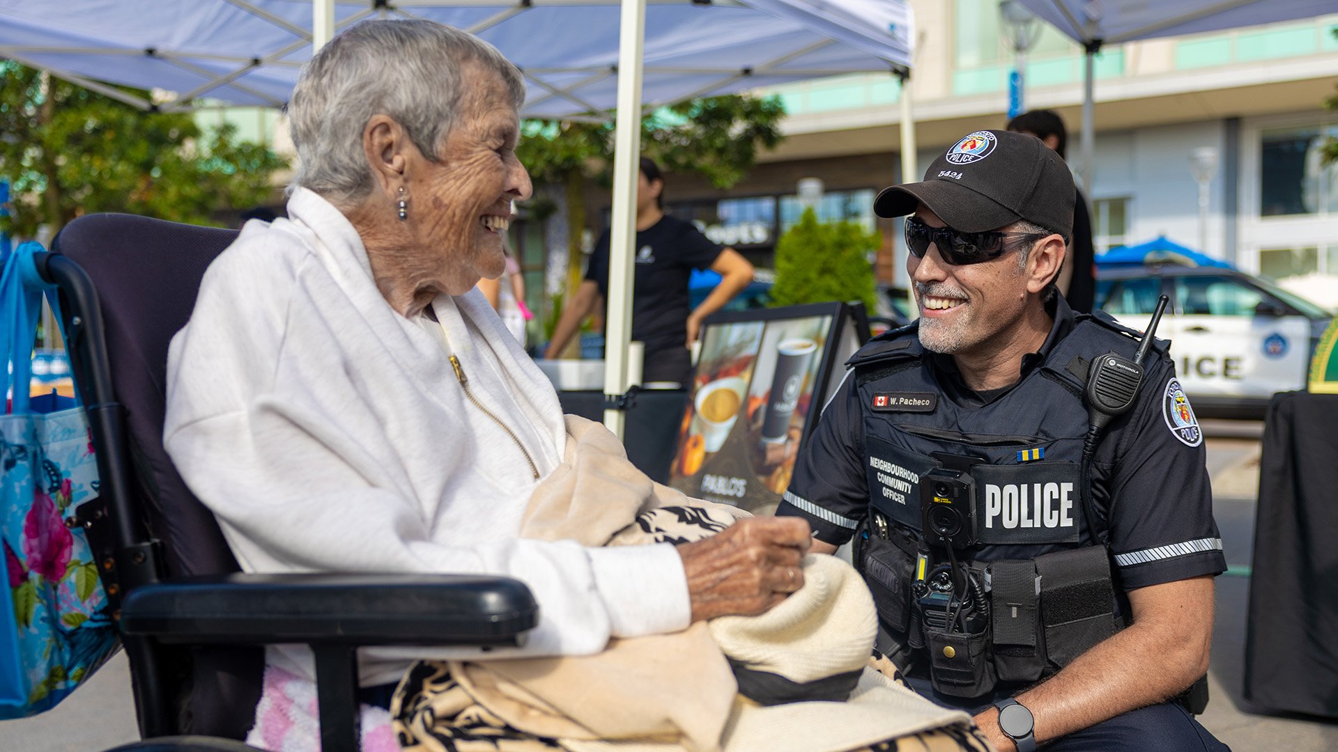 Officer kneeled beside woman in wheelchair.