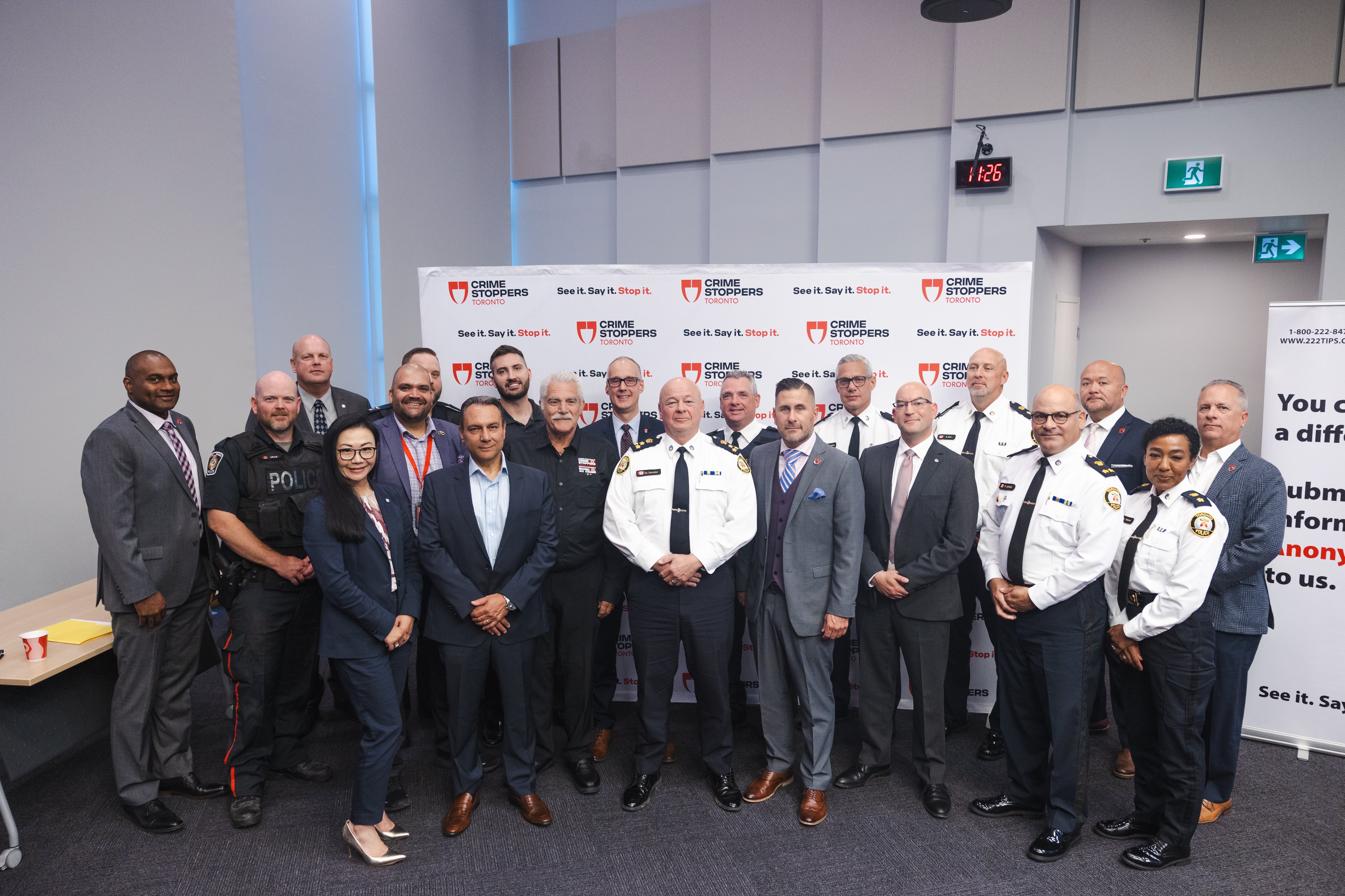 Members of Crime Stoppers and Toronto Police command pose for a photo
