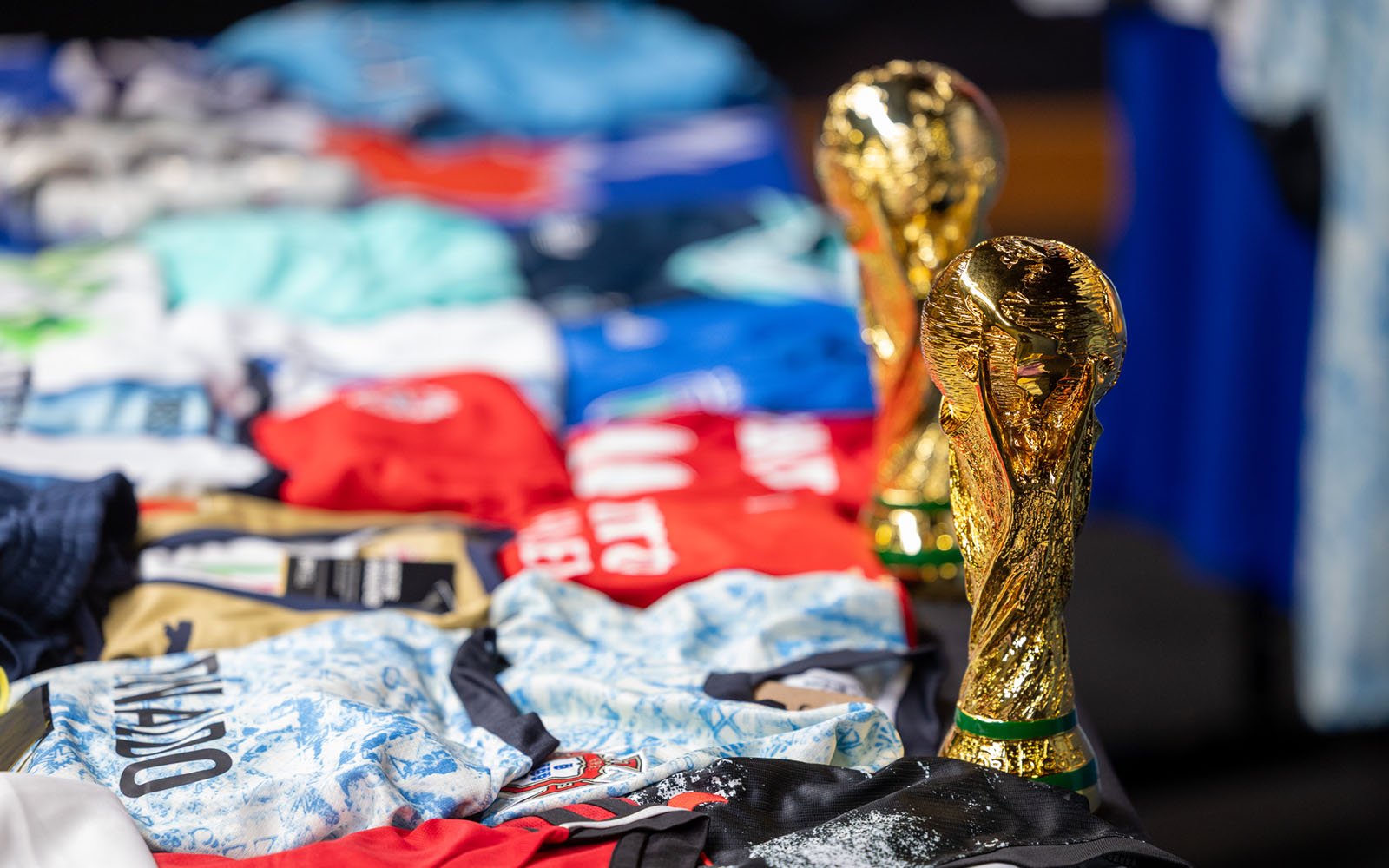 close up photo of a counterfeit fifa trophies, jerseys and flags