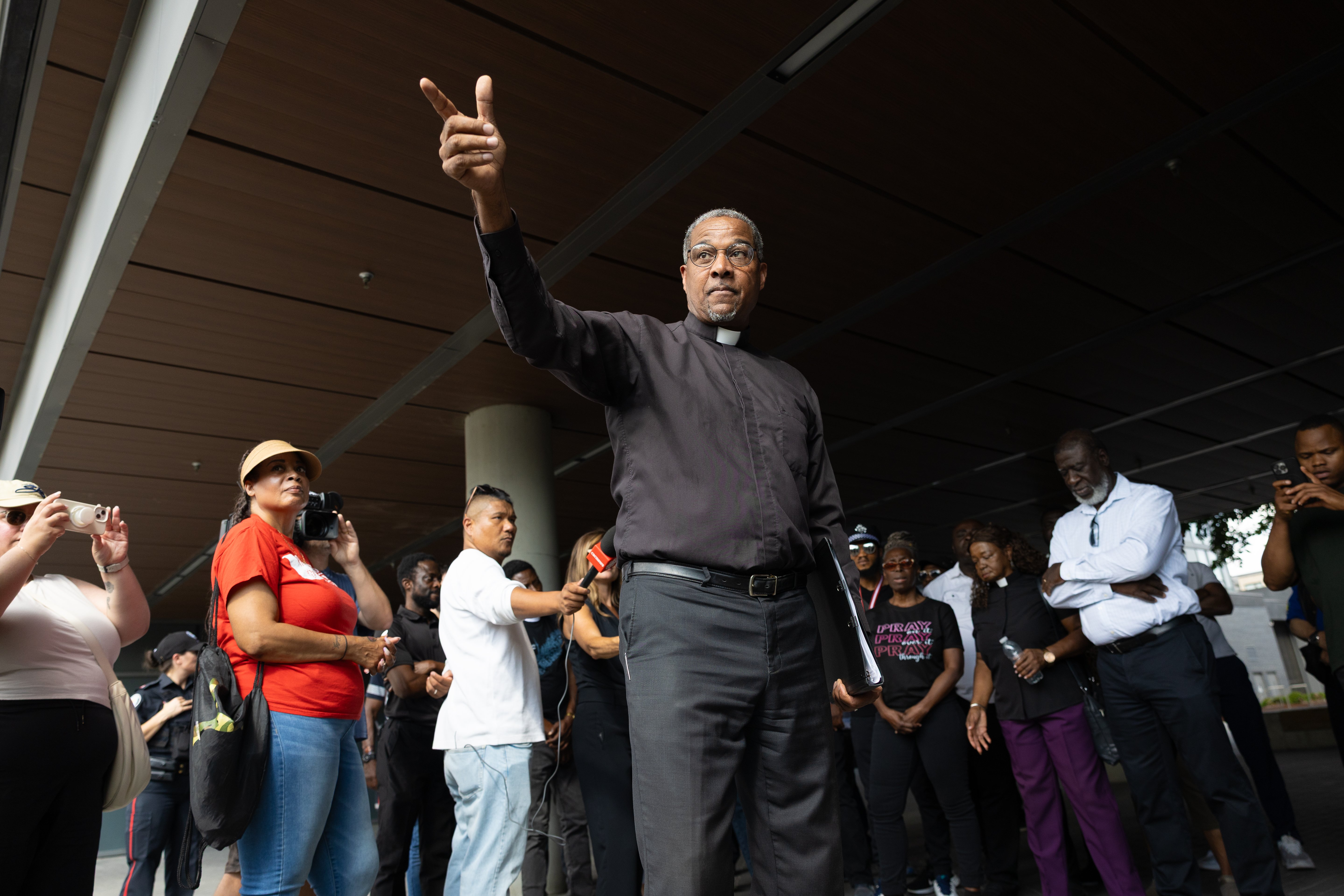 A pastor pointing his index finger to a crowd