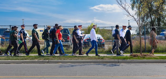 People walking on the sidewalk with a road in the foreground