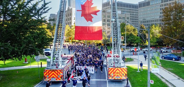 Runners under a large Canada flag