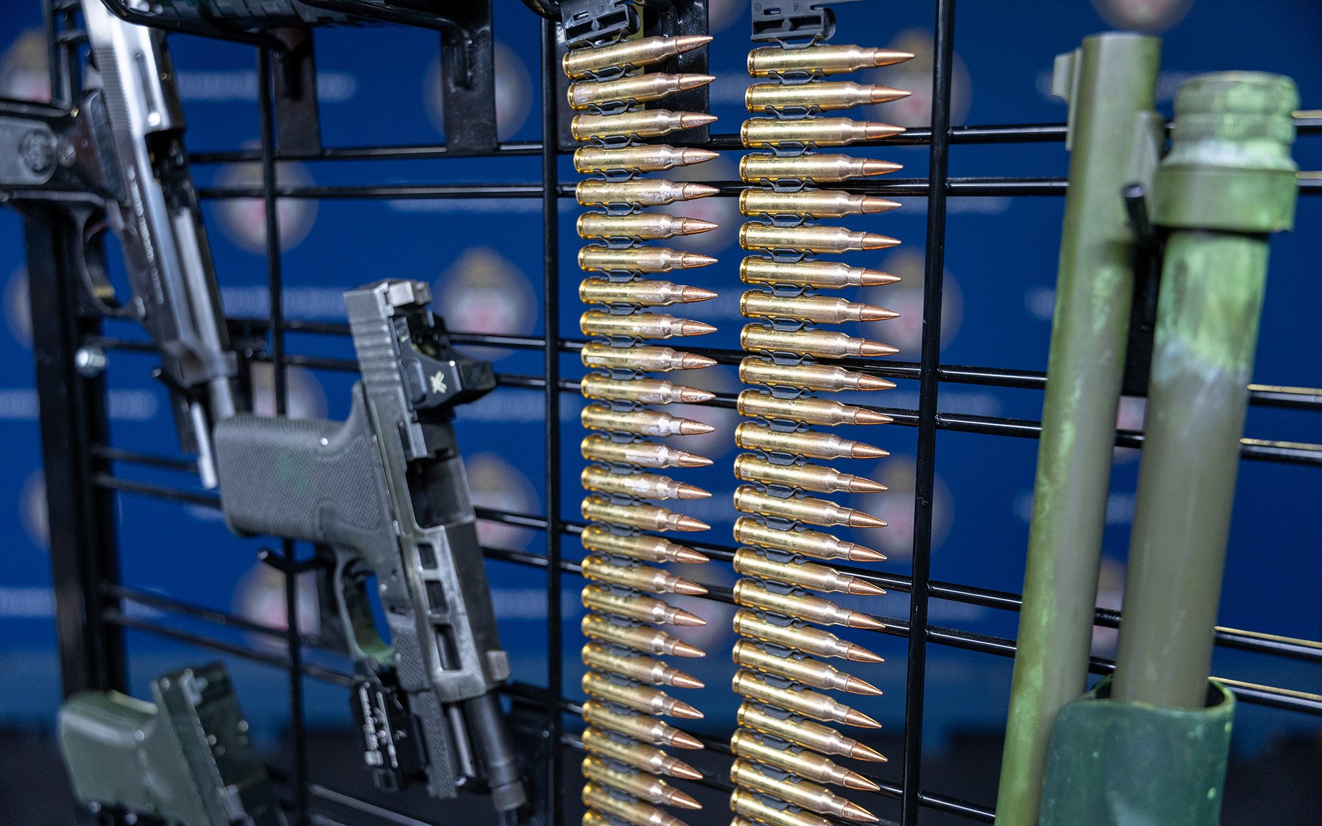 Guns and ammuntion on a metal rack.