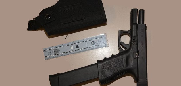 Gun, holster and ruler on a table
