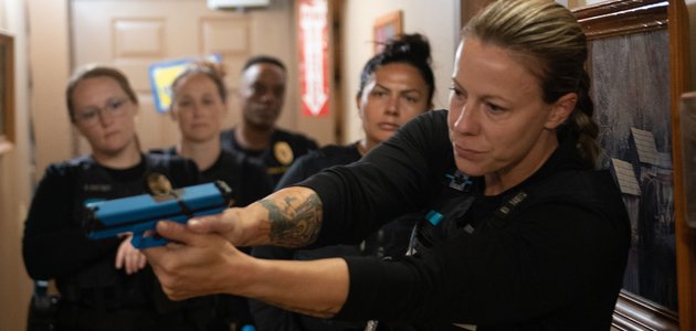 Person with a fake gun being watched by others