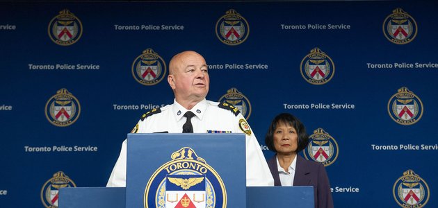 Police officer at a podium with person behind them