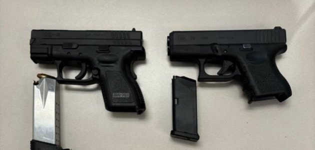 Two black handguns on a table