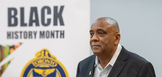 man standing infront of a banner that says black history month