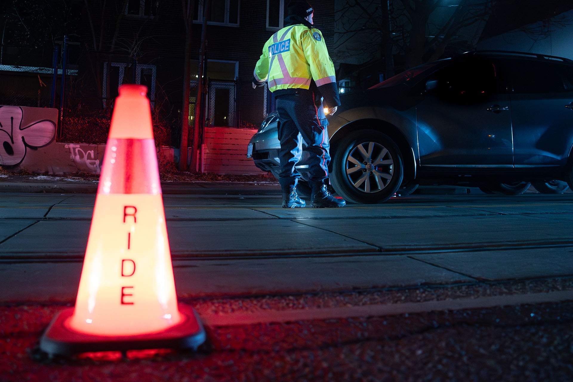 Police officer standing beside a car