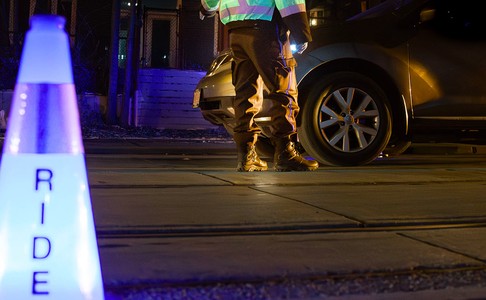Police officer standing beside a car